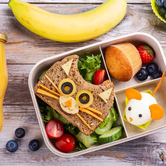 A silicone kids lunch container with food shaped like a cat and a mouse.