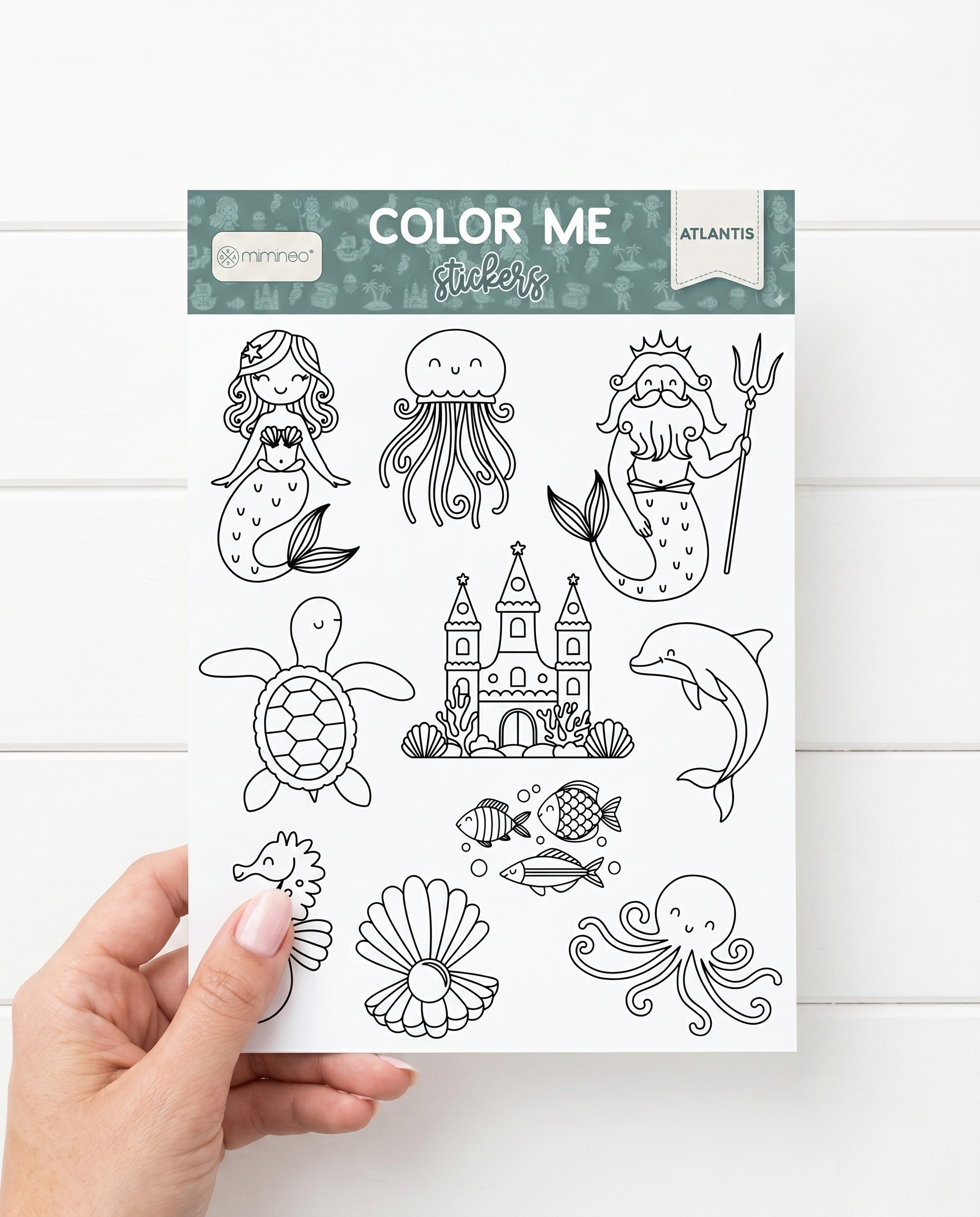 Coloring sheet with ocean-themed illustrations held by a hand on a white background