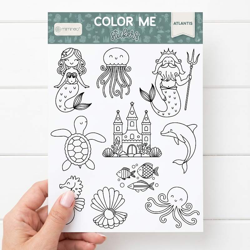 Coloring sheet with ocean-themed illustrations held by a hand on a white background