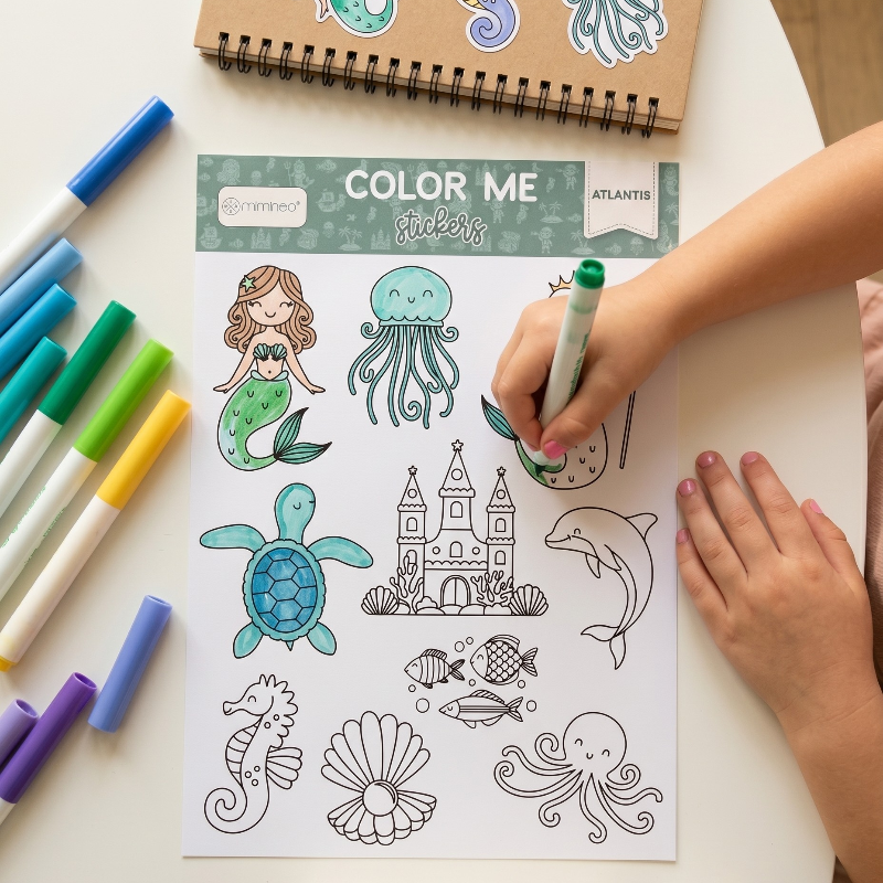 Coloring sheet Atlantis by MKS Miminoo with ocean-themed stickers and markers on a table