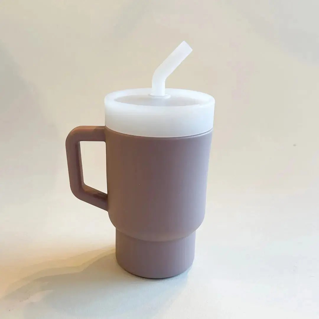 A lightweight 9oz toddler tumbler in soft, premium silicone, designed with a handle for easy grip and portability. The tumbler features a leak-resistant straw with a soft silicone tip, making it perfect for independent sipping. Available in playful colors for kids, it combines functionality with fun for little explorers. Lilac rose for little girls.