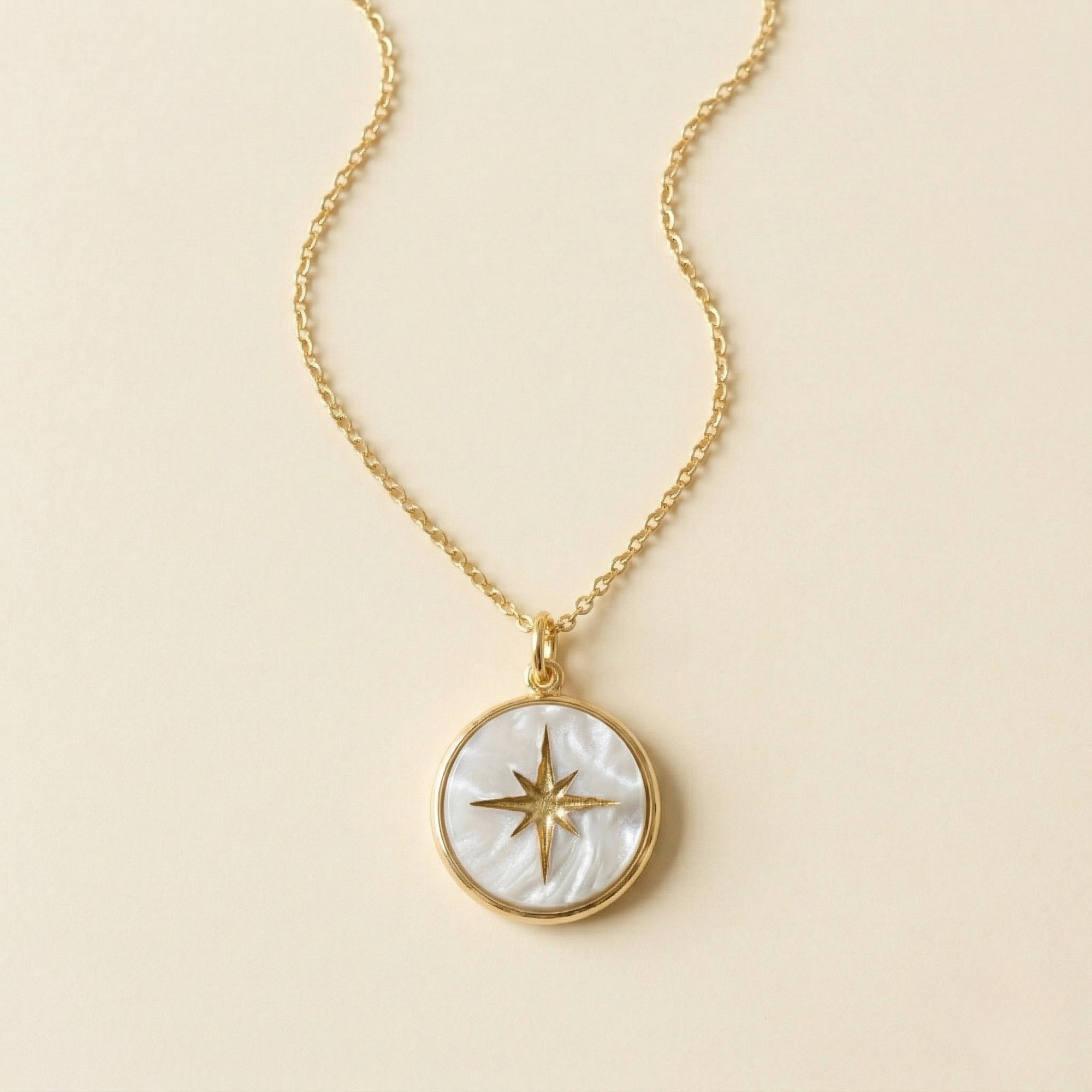 Close-up of Miminoo's Pearl Acrylic North Star Necklace featuring a round pearl marble acrylic charm with a hand-painted gold star, suspended from a delicate 18k gold-plated chain on a white background.