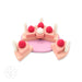 A pink Silicone Strawberry Cake Pretend Play Stacker with strawberries and candles to chew on by babies or pretend play birthday cake toy MKS Miminoo.