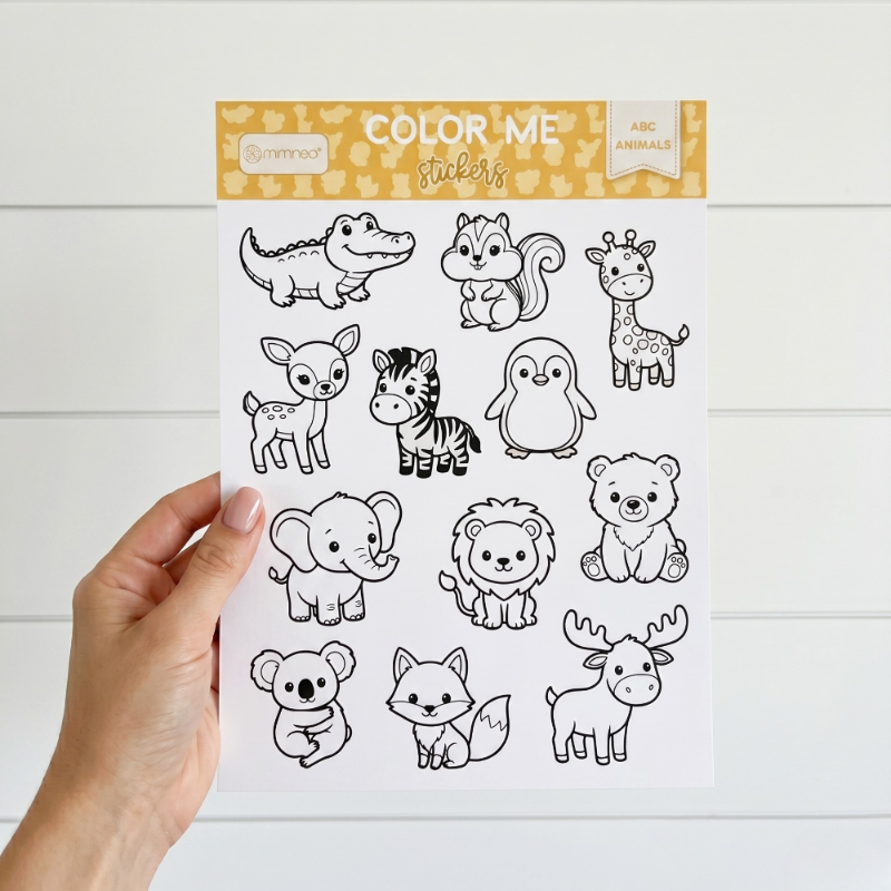 Sheet of animal stickers with 'Color Me' packaging on a white wooden surface