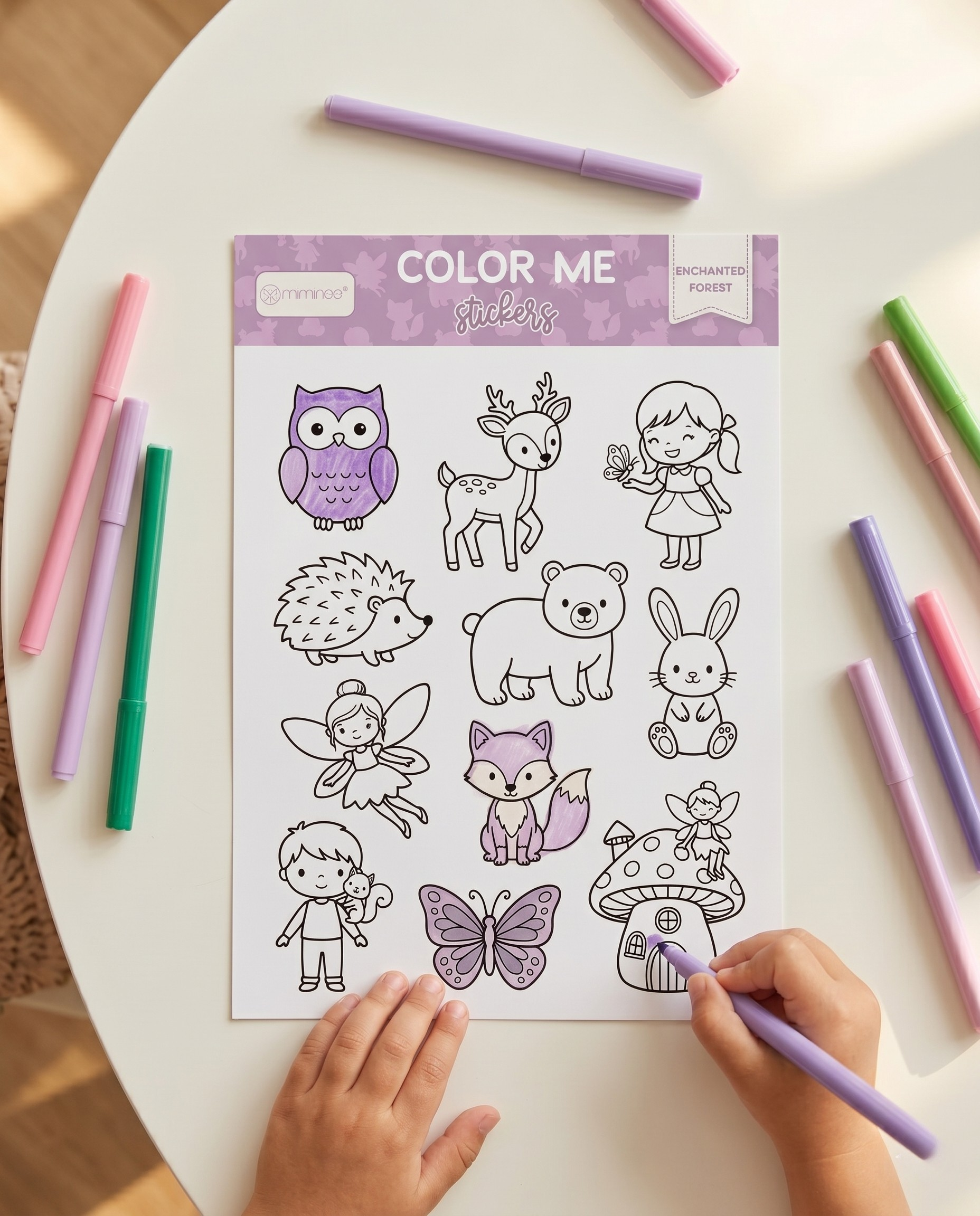 A hand holding a MKS Miminoo Color Me Enchanted Forest sticker sheet, featuring outline illustrations of an owl, deer, girl with butterfly, hedgehog, bear, bunny, fairy, fox, boy with squirrel, butterfly, and mushroom house, all ready for coloring.