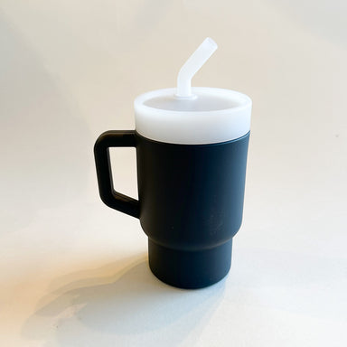 A lightweight 9oz toddler tumbler in soft, premium silicone, designed with a handle for easy grip and portability. The tumbler features a leak-resistant straw with a soft silicone tip, making it perfect for independent sipping. Available in playful colors for kids, it combines functionality with fun for little explorers. Midnight grey, unisex color for boys and girls.