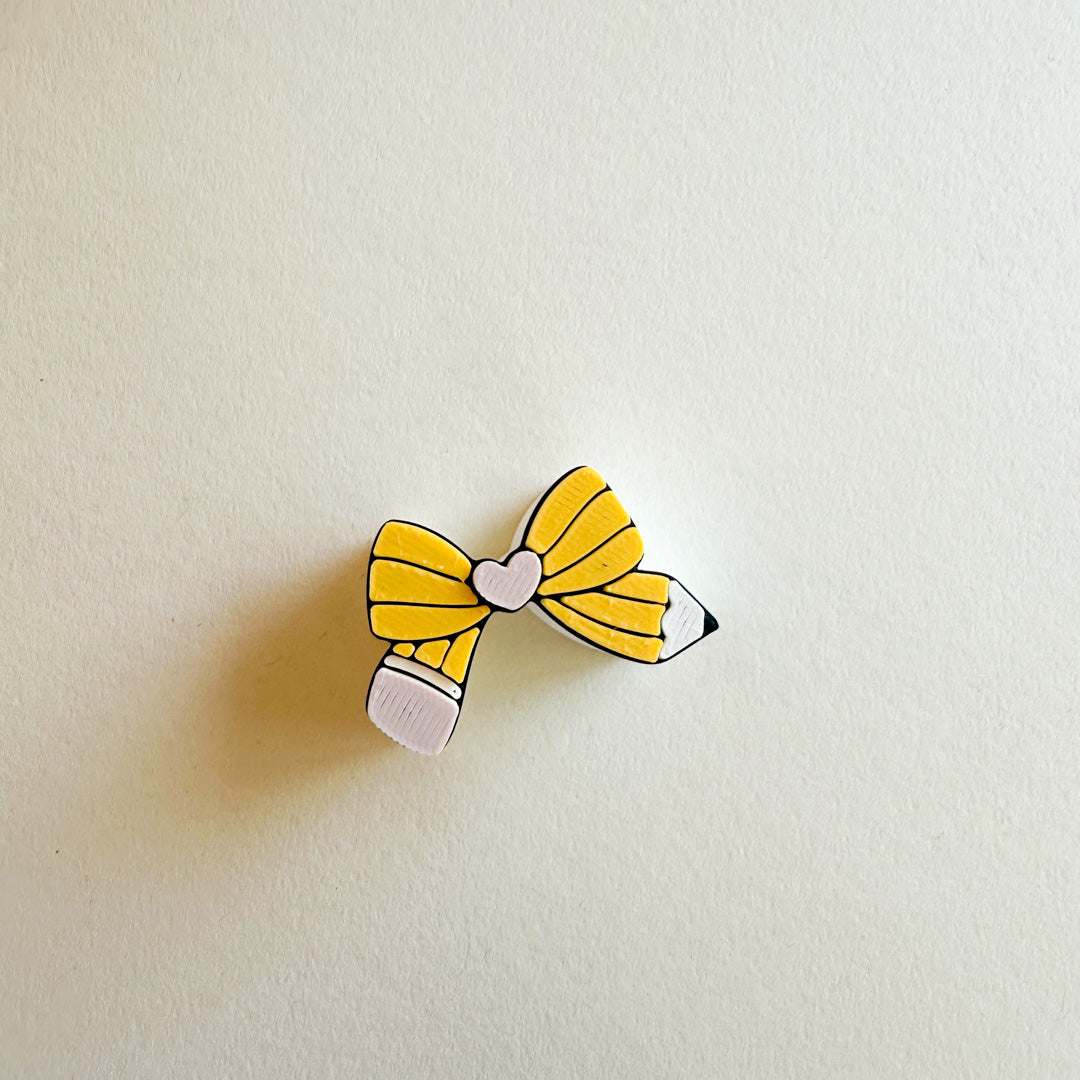 Yellow bow-shaped straw stopper on a beige background