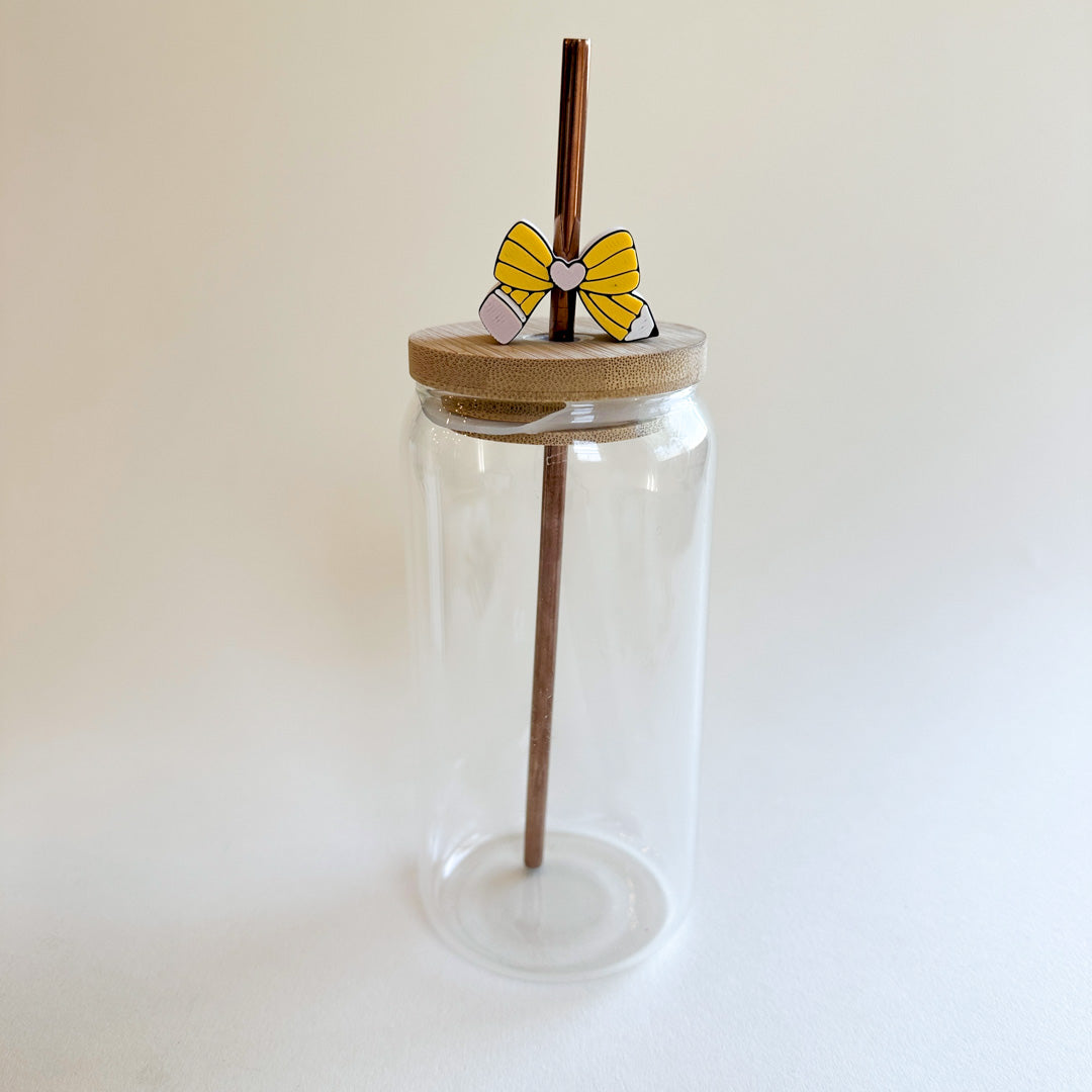 Clear glass tumbler with a wooden lid and straw on a white background