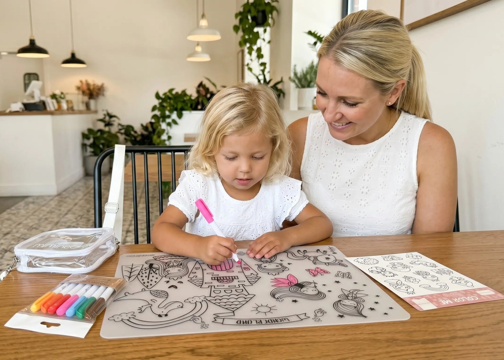 Woman and child sitting at a table with coloring materials in a home setting for a screen-free calm restaurant activities by Miminoo
