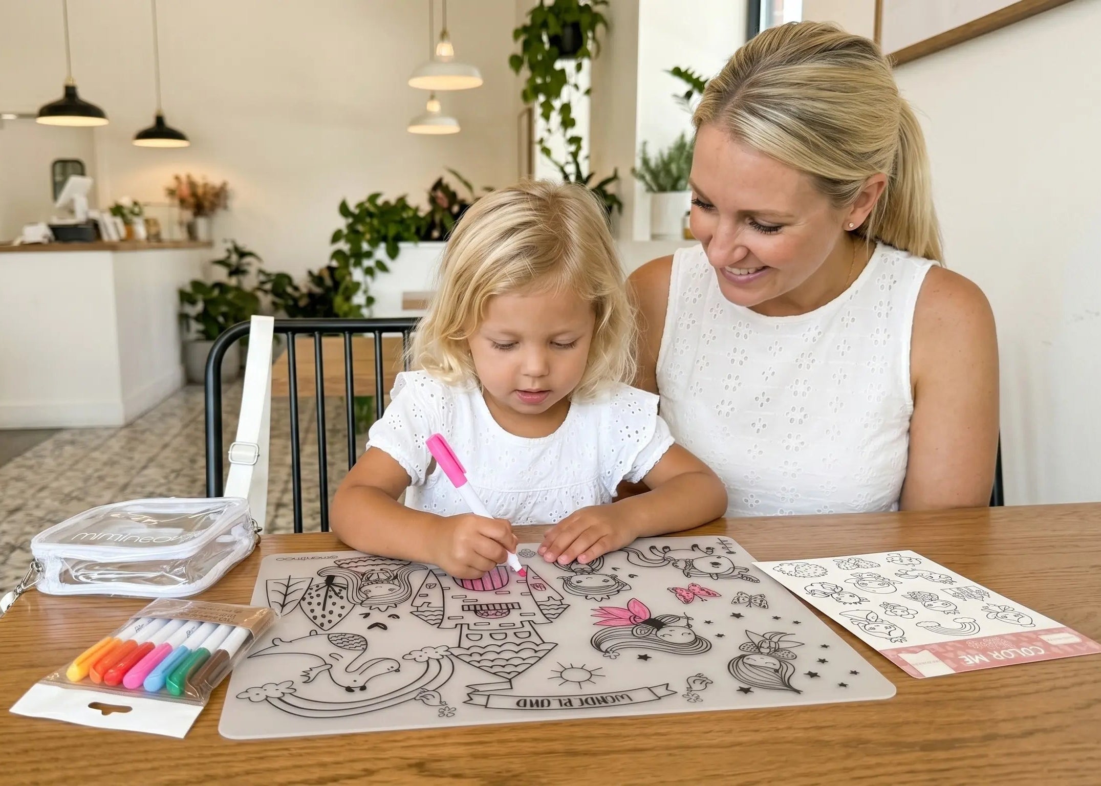 Woman and child sitting at a table with coloring materials in a home setting for a screen-free calm restaurant activities by Miminoo